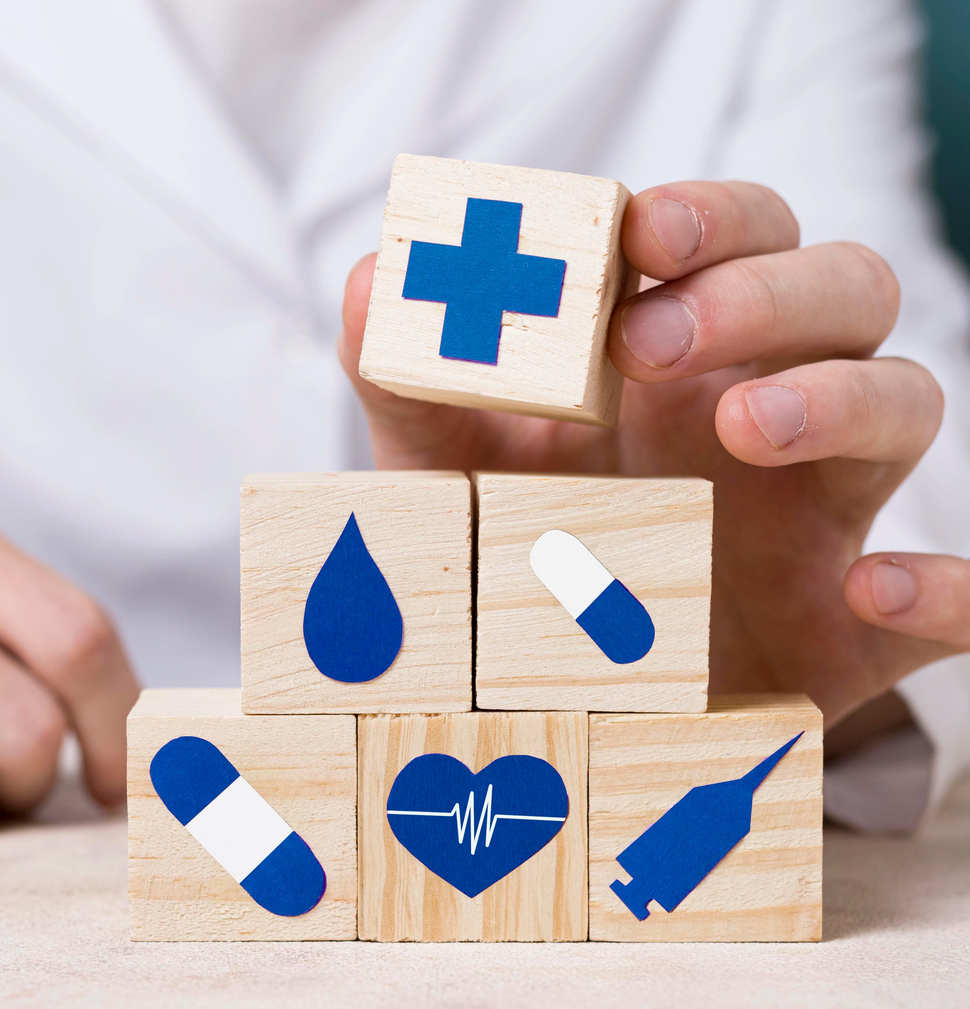 Imagem de um profissional de saúde com cubos de madeira representando benefícioss de um plano de saúde